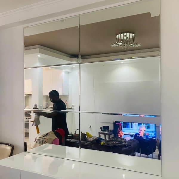 Painel de espelho sob medida instalado em parede de interior.